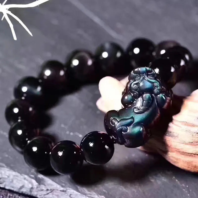 Natural ice colour eye obsidian crystal bracelet on a wrist, showing detail of the stone beads.