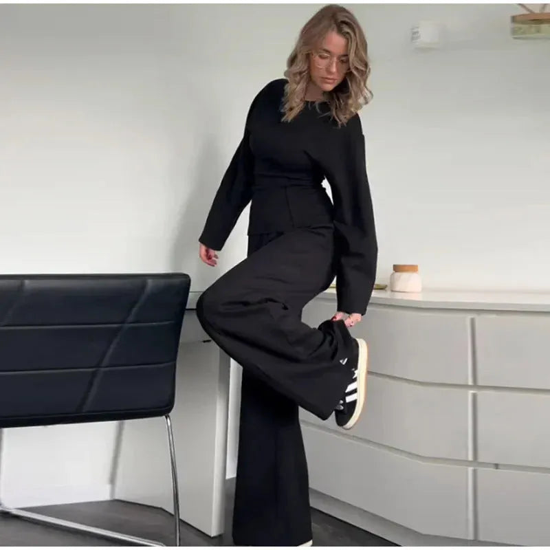 Women's black polar fleece long sleeve pleated top and wide leg trousers co-ord set on a hanger.