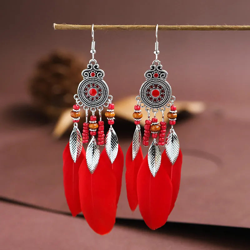 A pair of bohemian-style round drop earrings with a feather leaf pattern, shown in one of thirteen available colours.