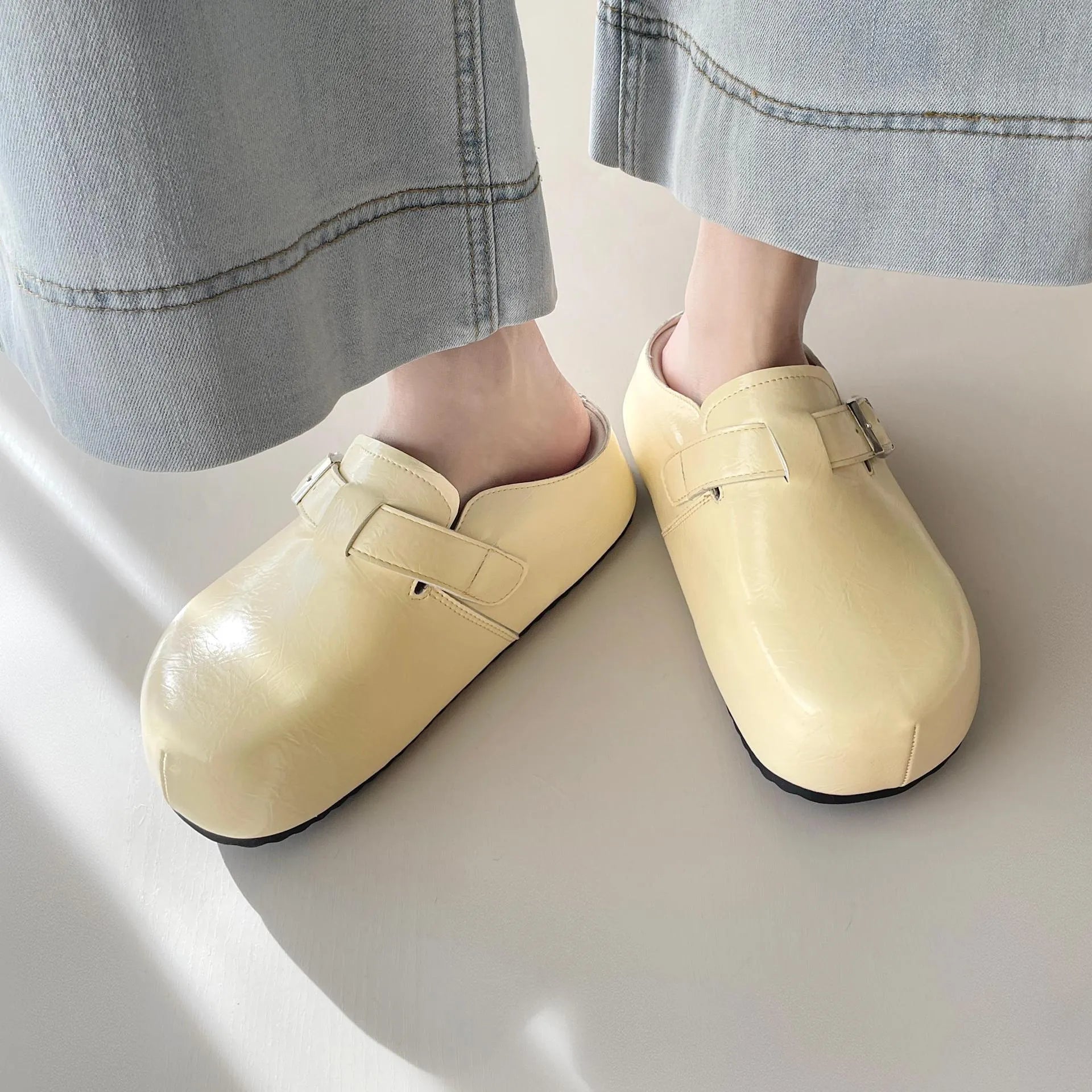 Flat buckle casual sneakers in yellow, black, silver, and creamy-white colours with rounded toe shape