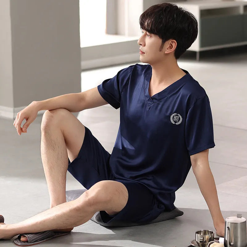 Man wearing a loose light blue short-sleeve pajama shirt and matching shorts, labelled as ice silk sleepwear.