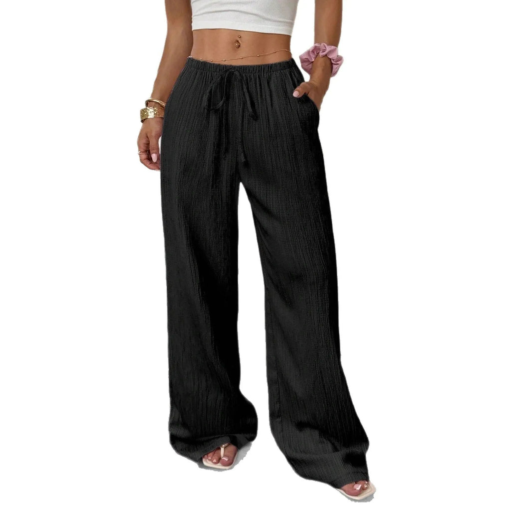 Women's black wide leg trousers with lace-up waist detail showing adjustable fit feature