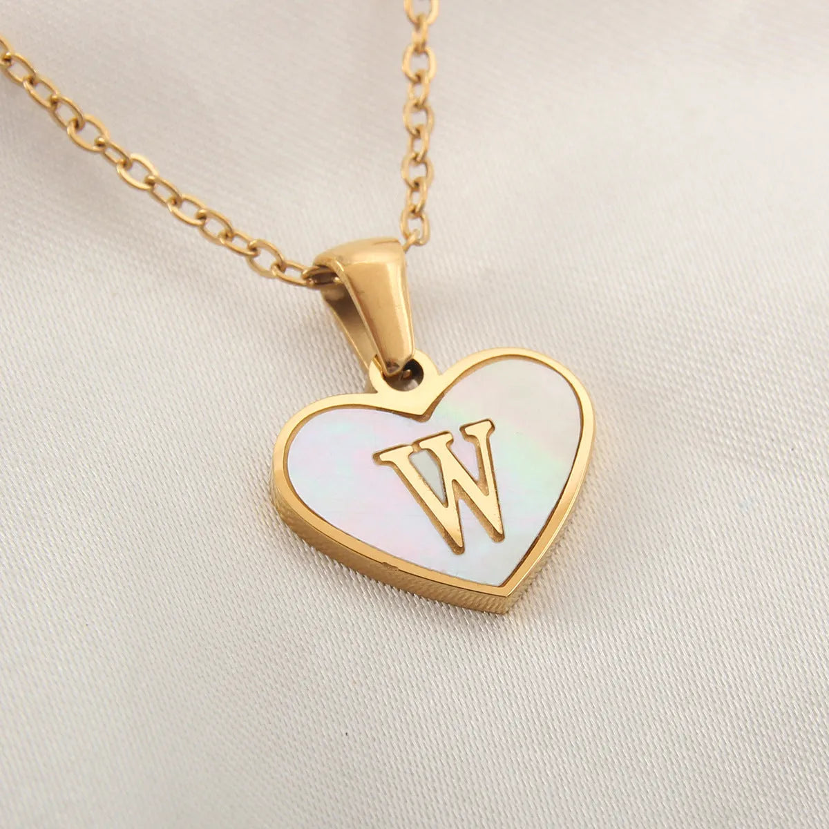 Gold plated heart-shaped white shell pendant personalised initial necklace on a stainless steel chain.