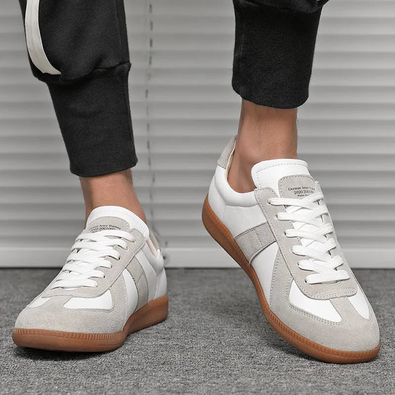 White retro unisex board sneakers with lace-up front and round toe on a rubber sole.