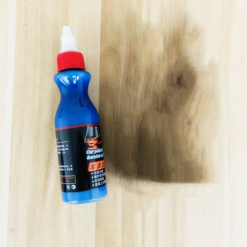Small blue container of scratch repair agent with integrated wiping tool for automotive paint