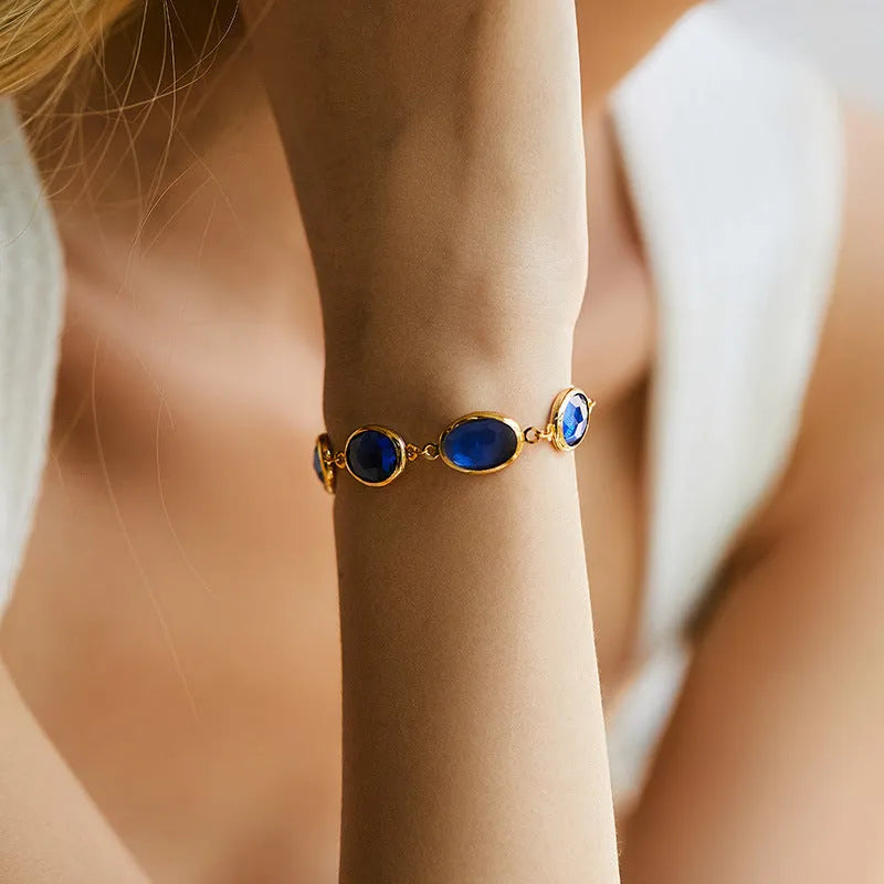 Geometric elliptical women's bracelet with blue glass inlay on an 18K copper band.