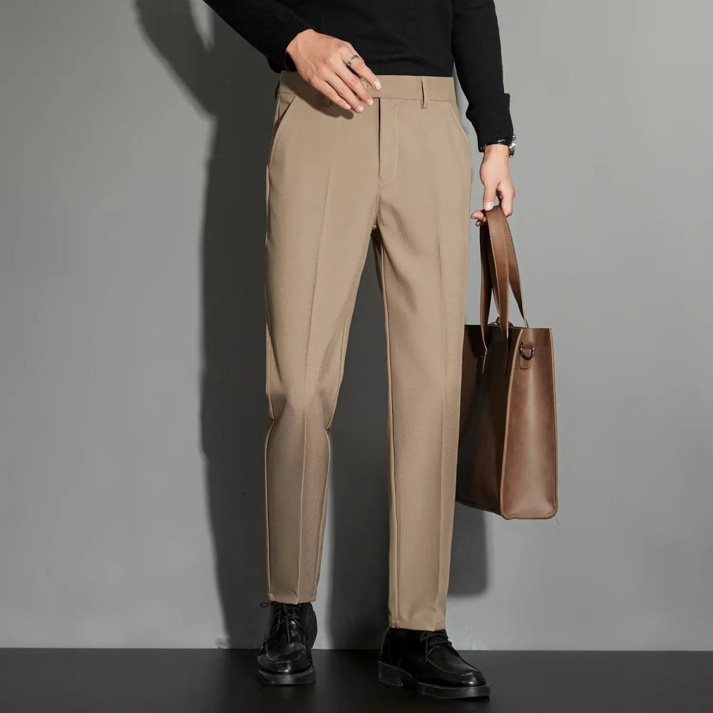 Man wearing straight-leg suit trousers with an ankle-length draping effect in a light colour.