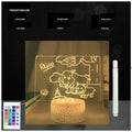 Black 3D acrylic message board night light on desk with remote control and stylus.