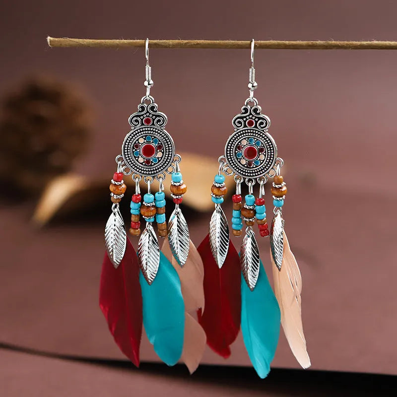 A pair of bohemian-style round drop earrings with a feather leaf pattern, shown in one of thirteen available colours.