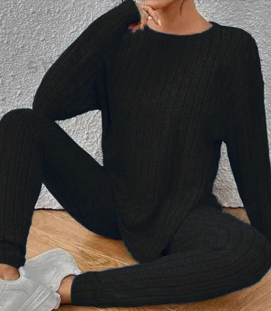 Women's black two-piece lounge set with a sunken stripe pattern on the top and matching trousers.