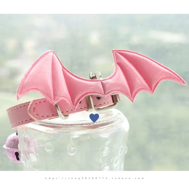 Small leather dog collar with decorative devil wings and bell in patent leather satin