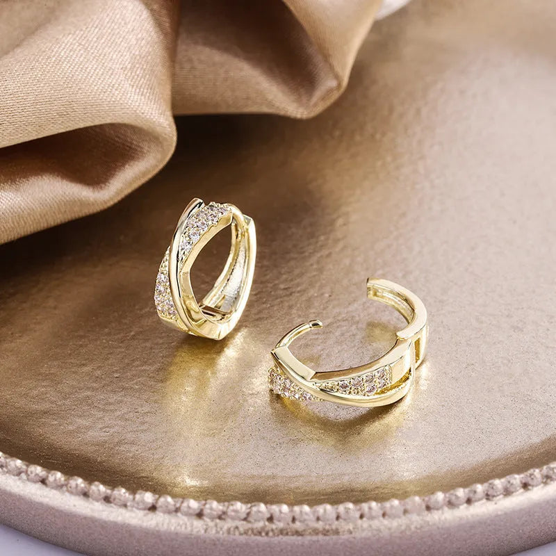 A pair of geometric drop earrings made from copper with zircon detailing and a 14K yellow finish.
