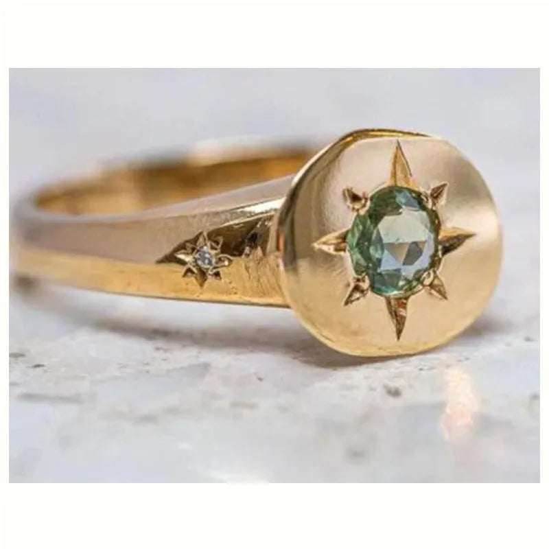 Gold-coloured adjustable ring with a star-shaped asterism zircon stone on a zinc alloy band.