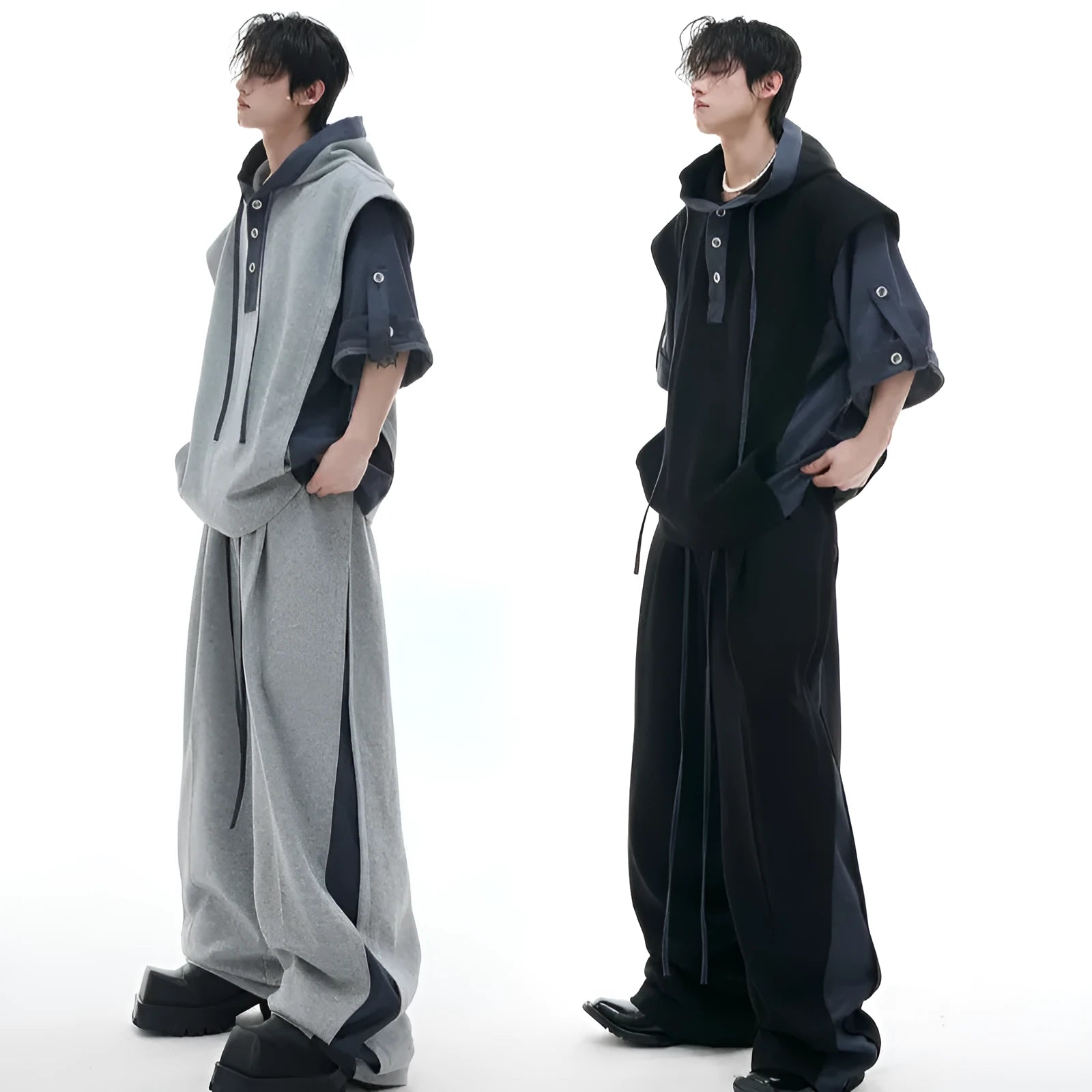 Man wearing a black hooded short-sleeve polyester tracksuit jacket and grey matching trousers.