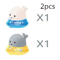 White and blue whale-shaped bath toy with water spray and LED lights floating in water