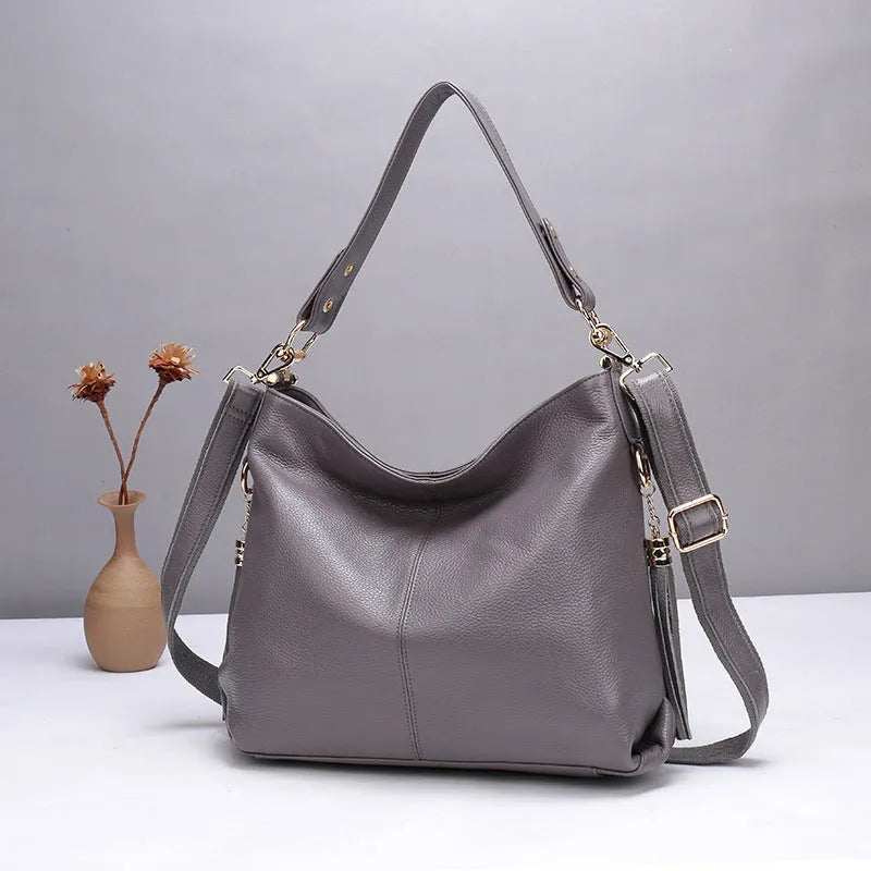 Genuine leather women's crossbody bag in square vertical design, showing internal zipped phone and document pockets.