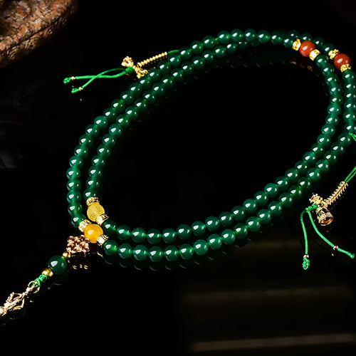 Natural green agate multi-strand bracelet with sliding knot closure on a wrist.