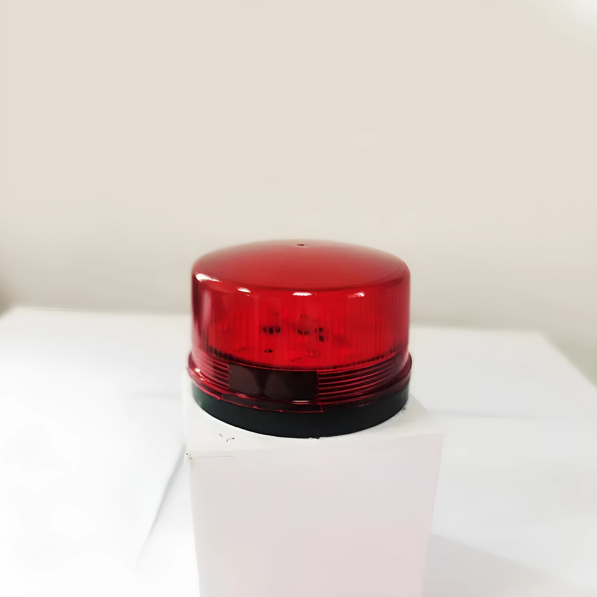 Small red 24V warning and alarm light with strobe flash and siren, model HC-79, on its mounting base.