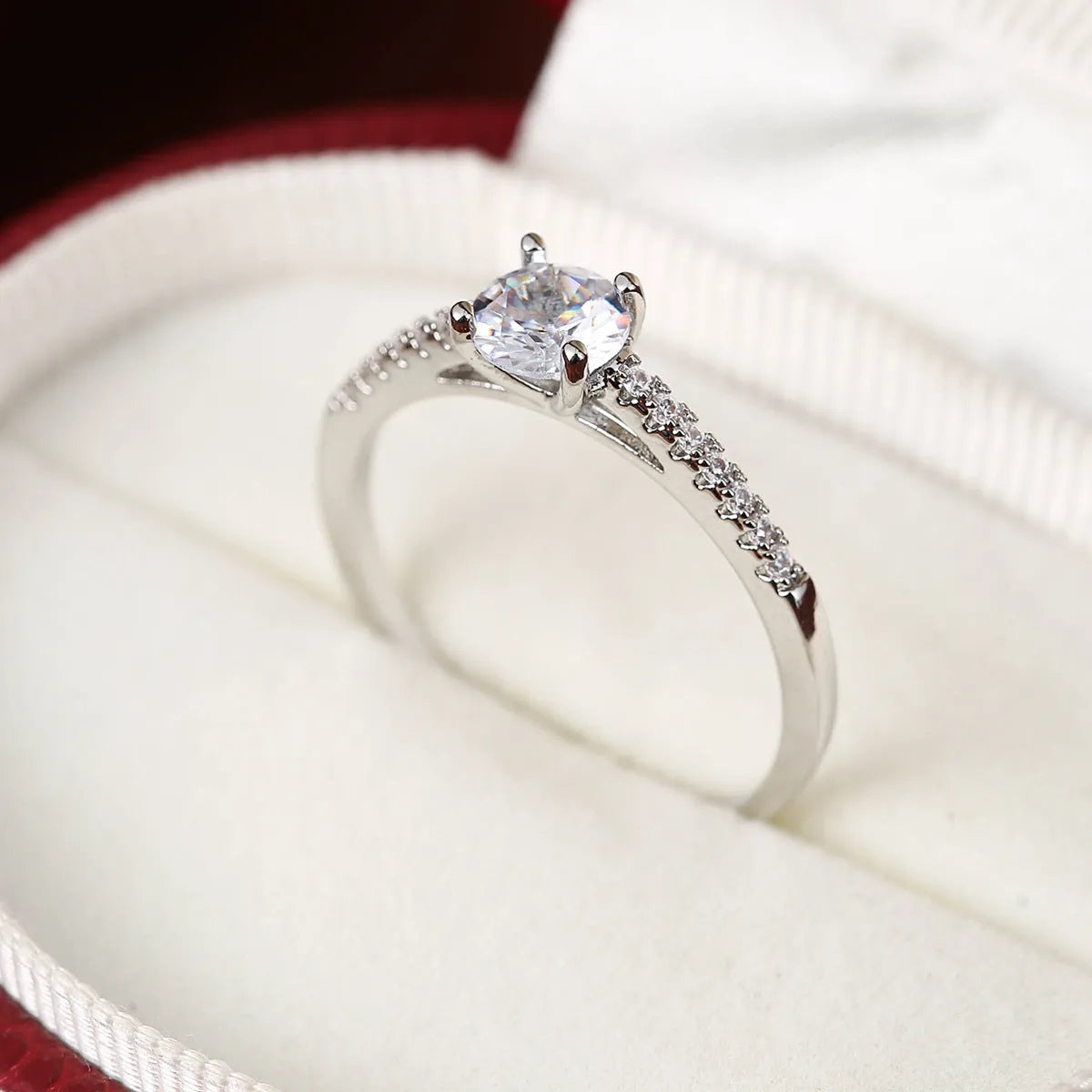 Hexagon geometric zircon ring on a finger, showing electroplated gold rose red colour and copper band.
