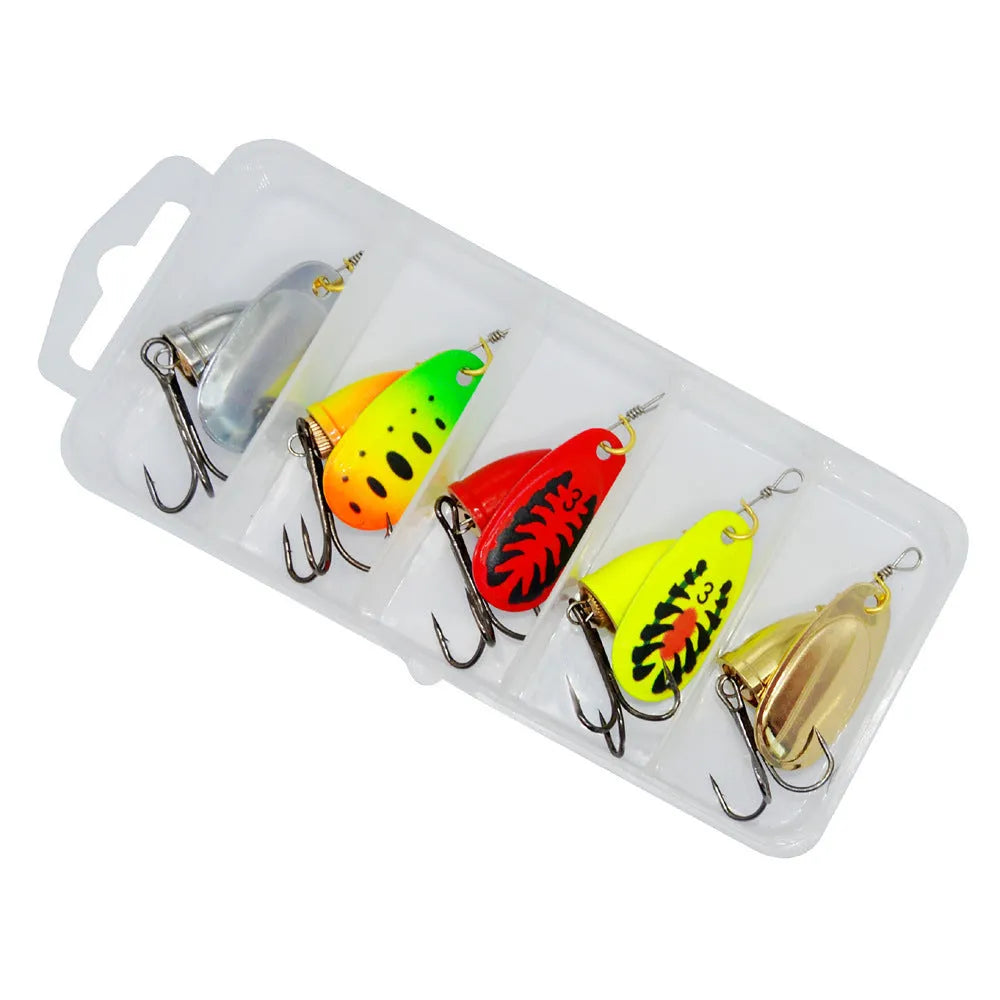 Copper bell metal fishing lure with rotating sequins in seven colour finishes on a blue background.