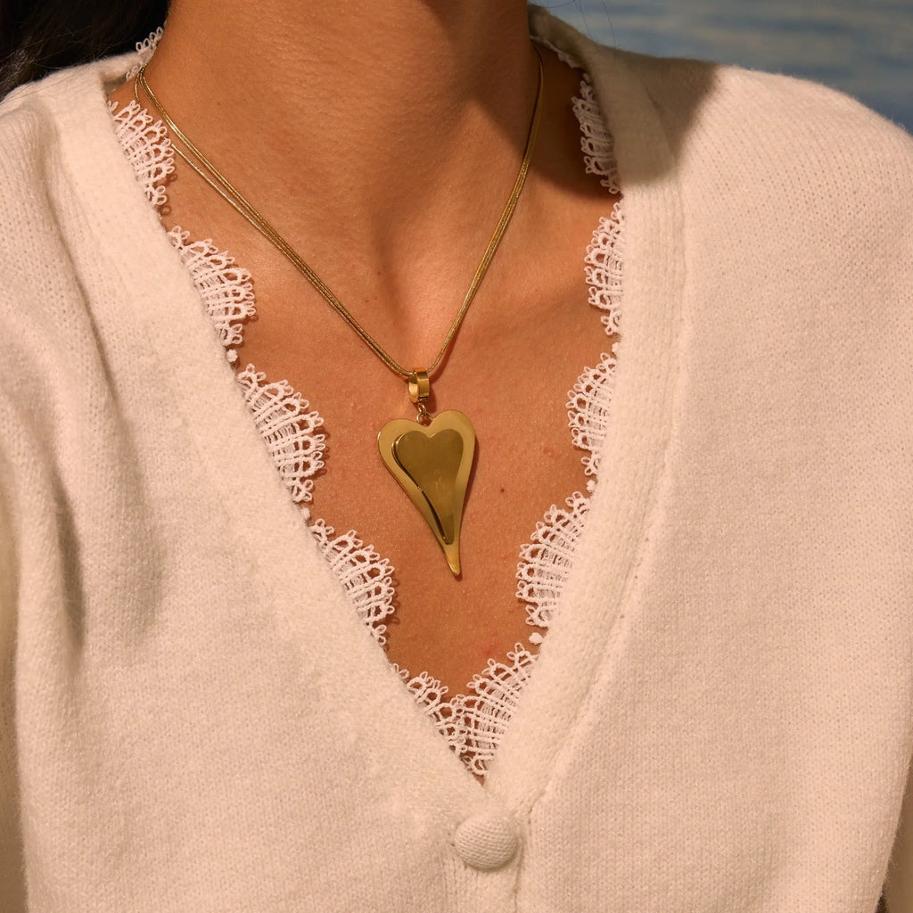 Close-up of a women's stainless steel necklace with a geometric double heart and snake bones chain design.