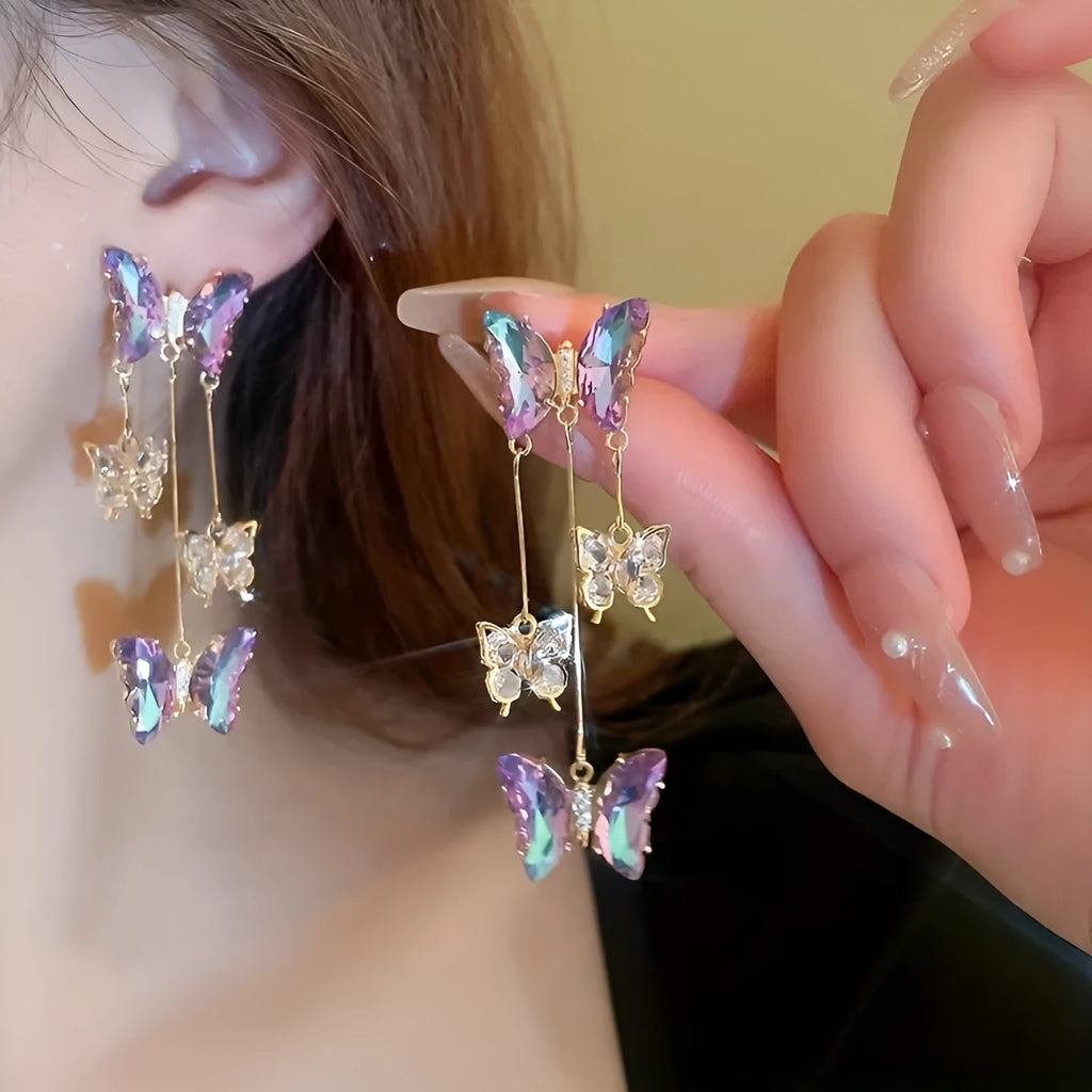 Silver electroplated alloy drop earrings with a blue purple butterfly charm and crystal flower details on a tassel.