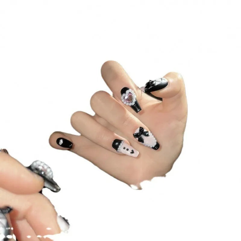 Black and pink heart hand-painted detachable artificial nails with bow design, shown in sizes XS, S, M, L.
