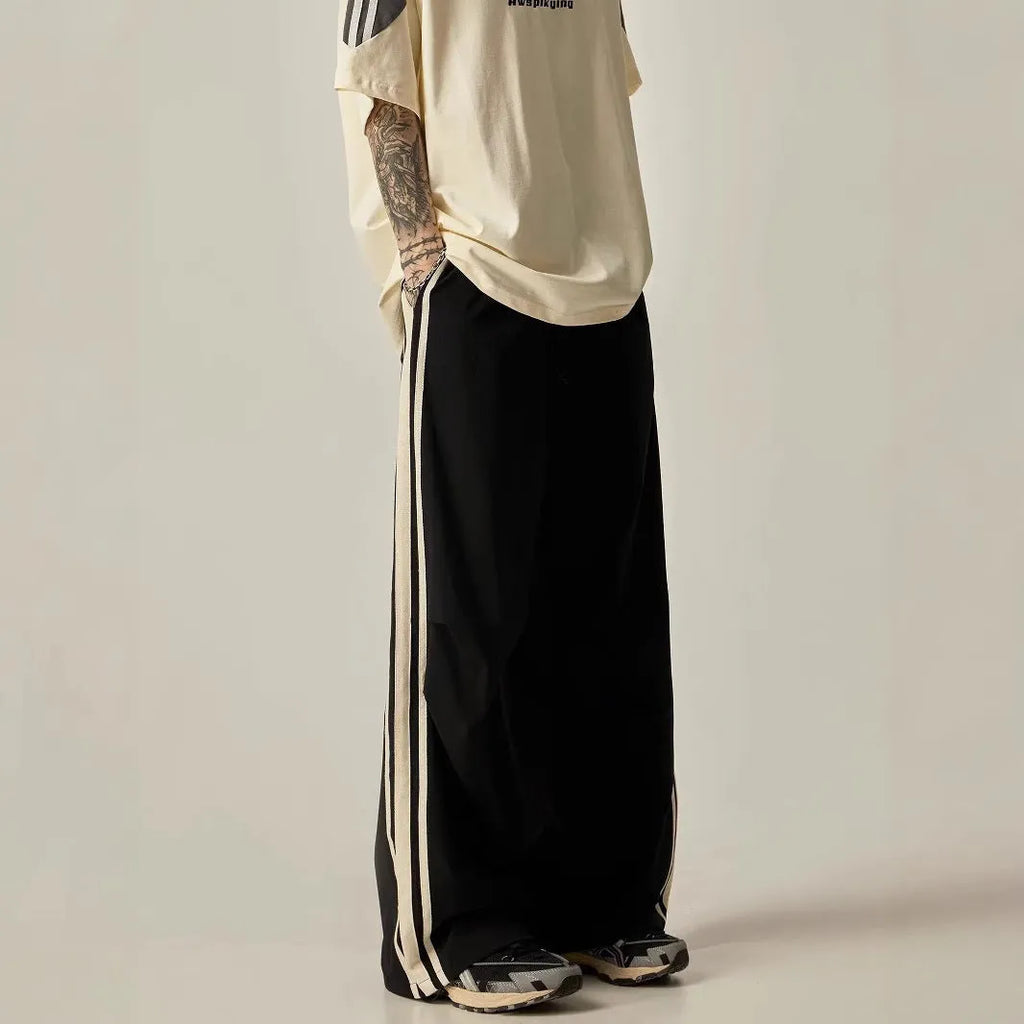 A man wearing black high-waisted wide-leg straight-cut casual climbing trousers.