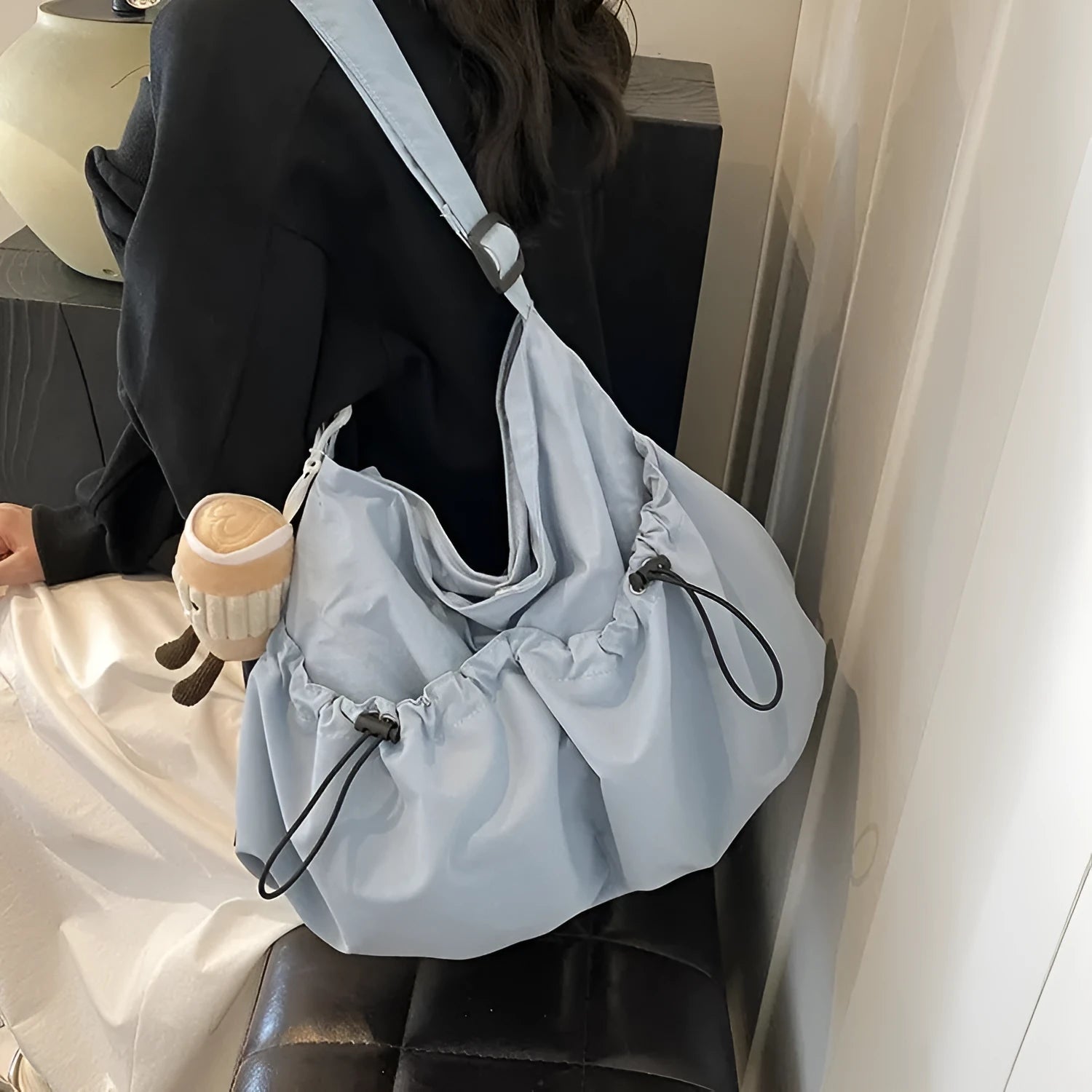 Ultra-light pleated green crossbody cloth bag lying flat, showing its split pocket and foldable design.