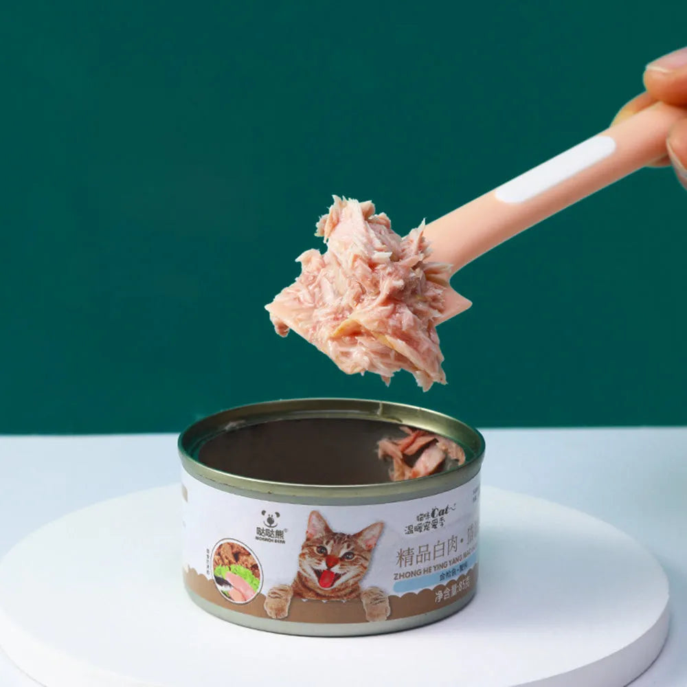 Green long-handle pet feeding spoon for canned cat and dog food on a white background.