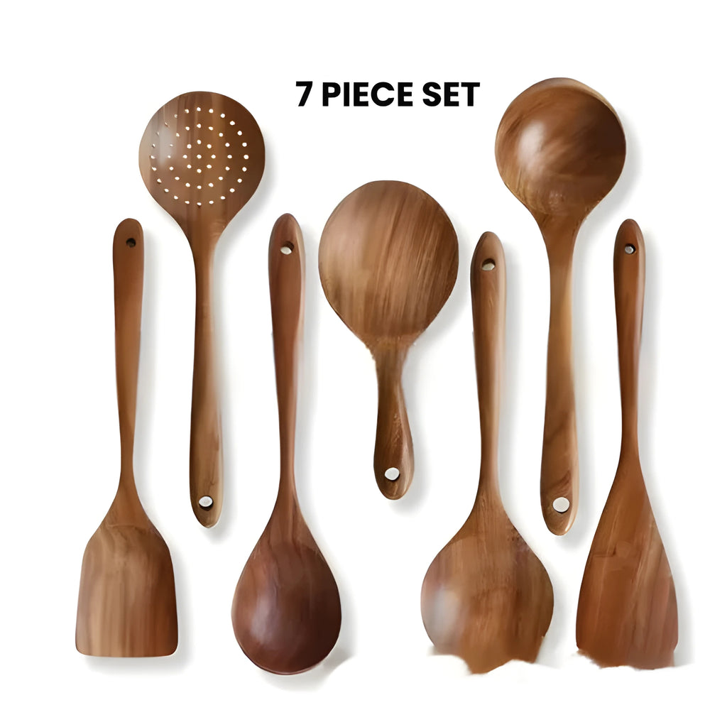 Boxed set of seven wooden kitchen spoons and spatulas on a table.