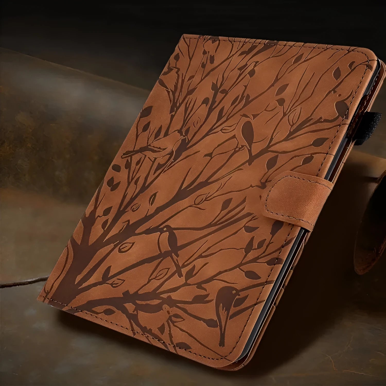 Imitation leather tablet case in black with integrated stand bracket, shown next to a tablet.