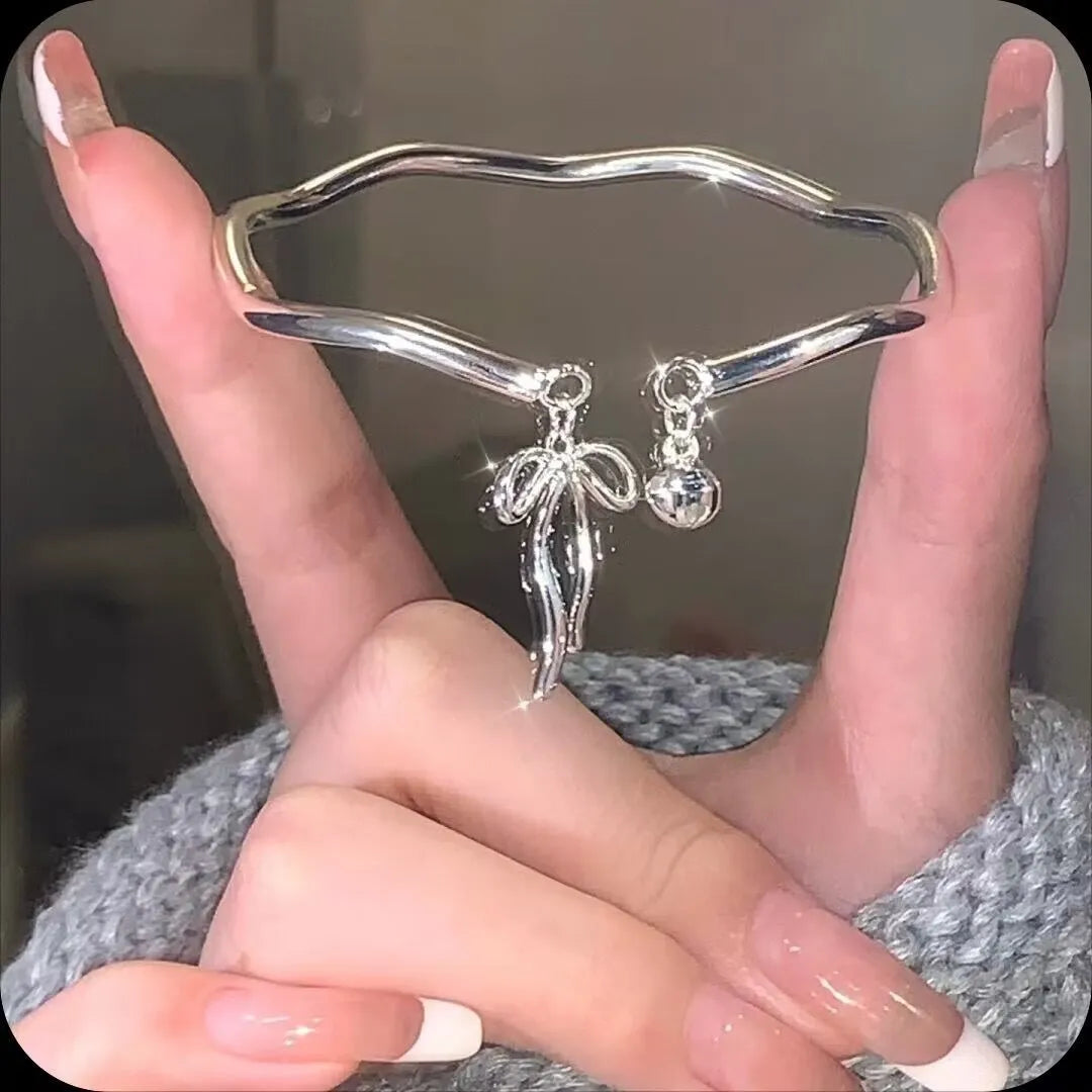 Silver adjustable bracelet with bow charm and bow bell opening clasp
