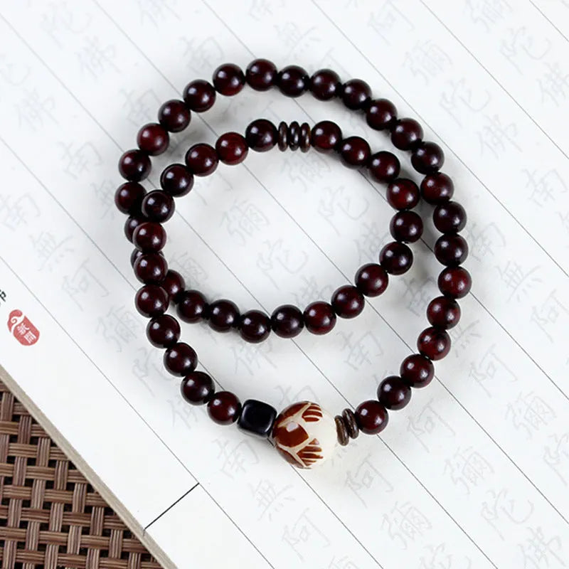 Rosewood bracelet with floral bead and knitted construction showing natural wood texture