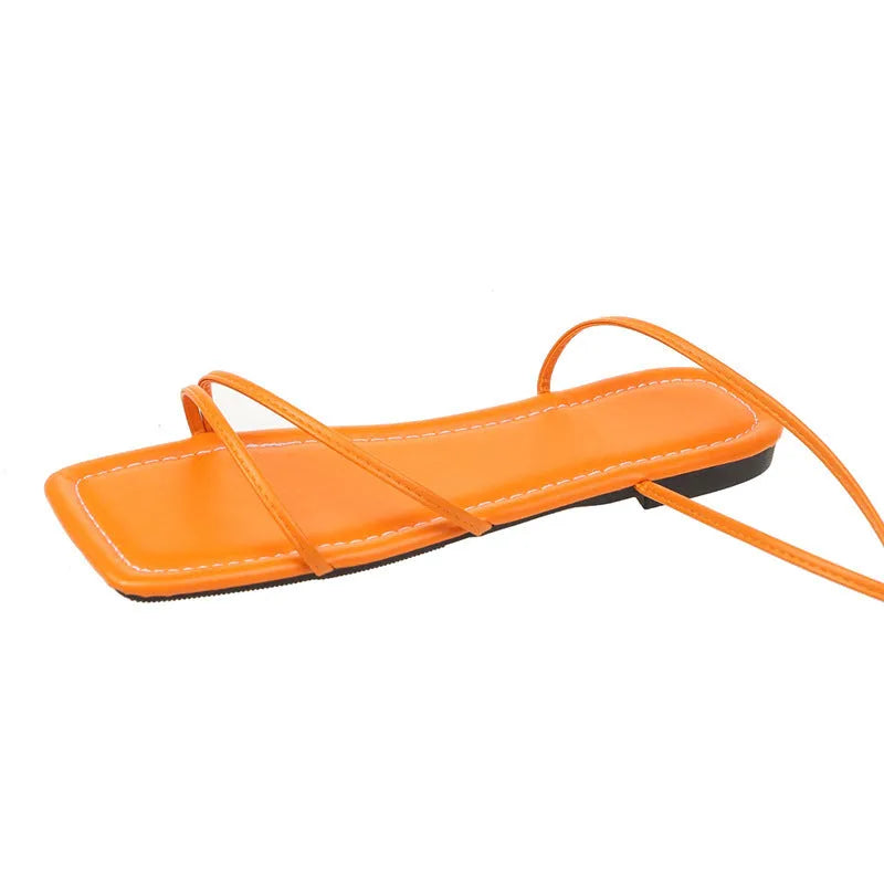 Women's flat sandals with ankle bandage cloth and lace-up closure in black, orange, or white.