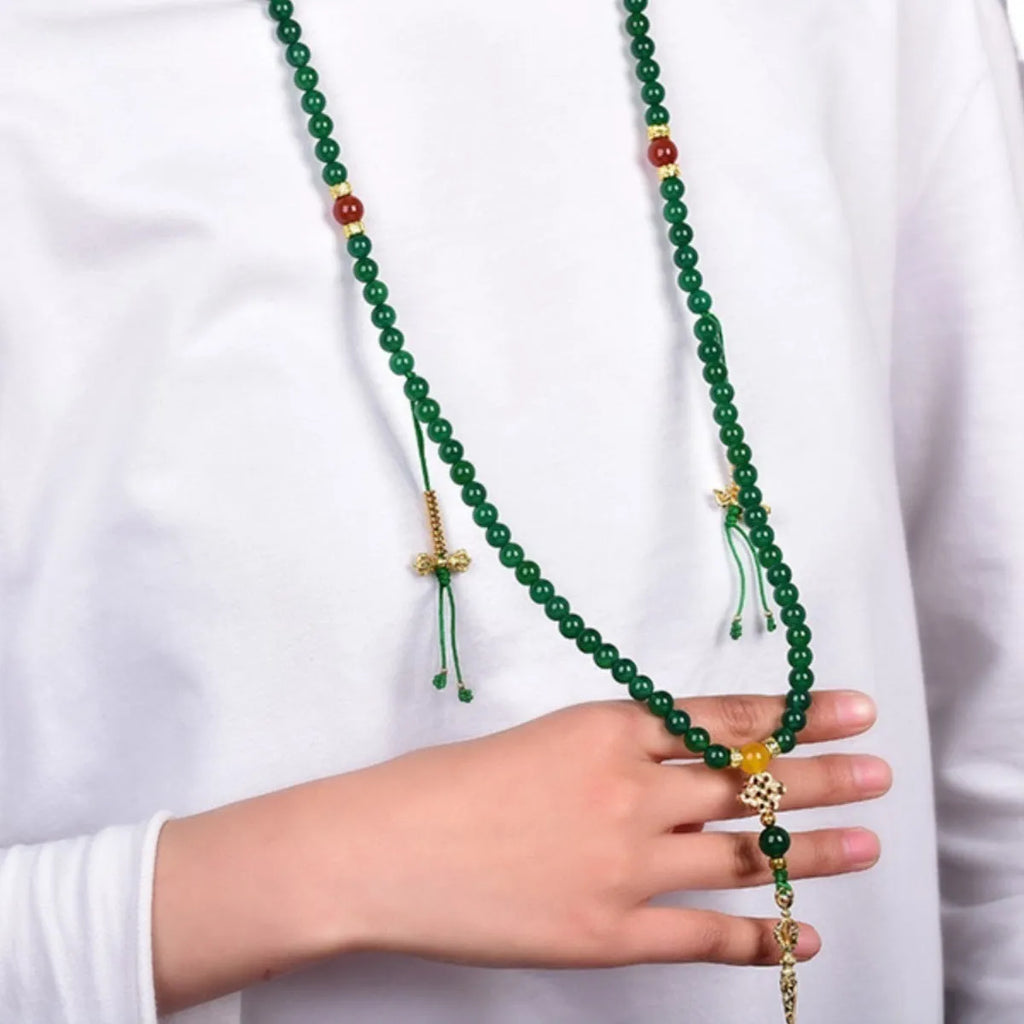 Natural green agate multi-strand bracelet with sliding knot closure on a wrist.