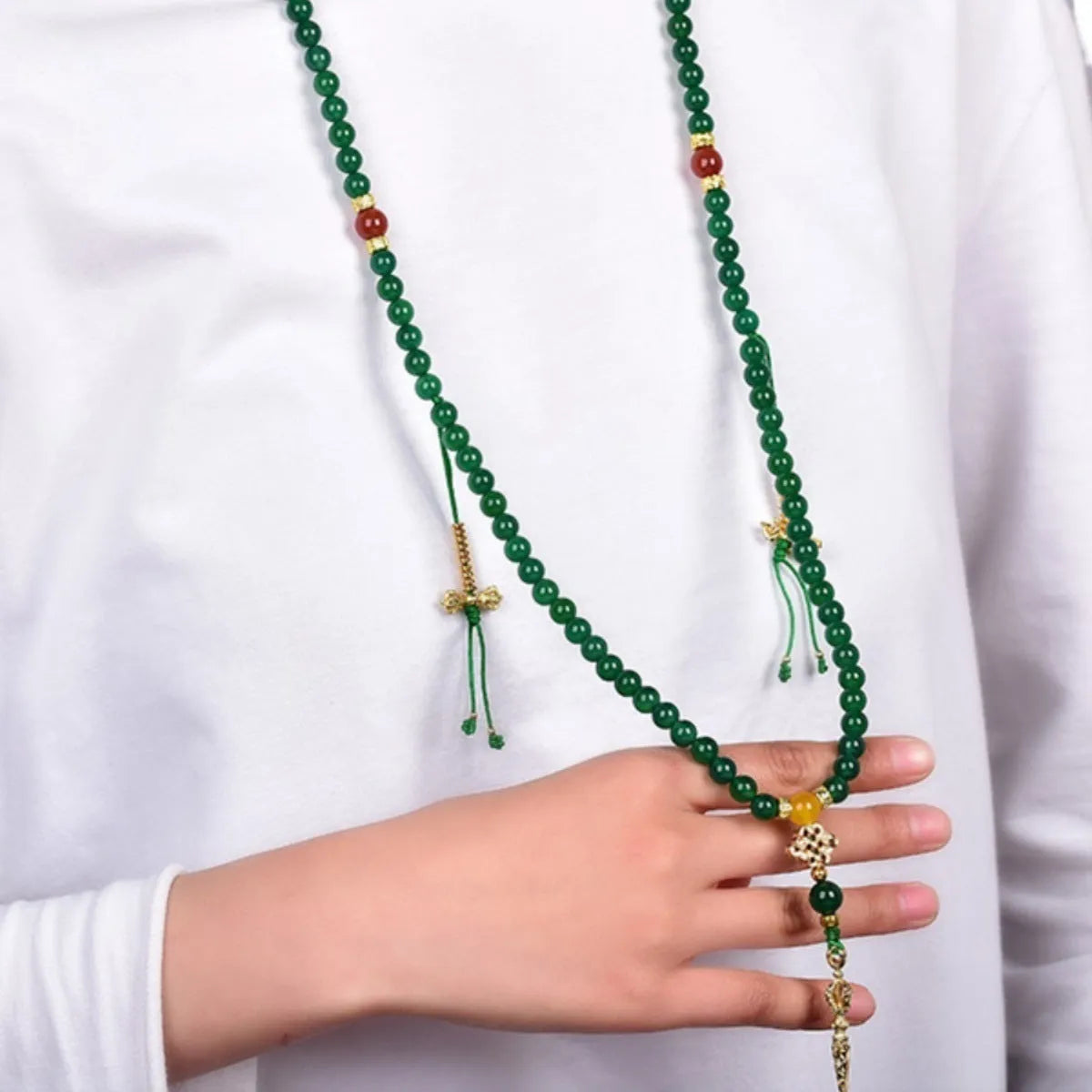 Natural green agate multi-strand bracelet with sliding knot closure on a wrist.