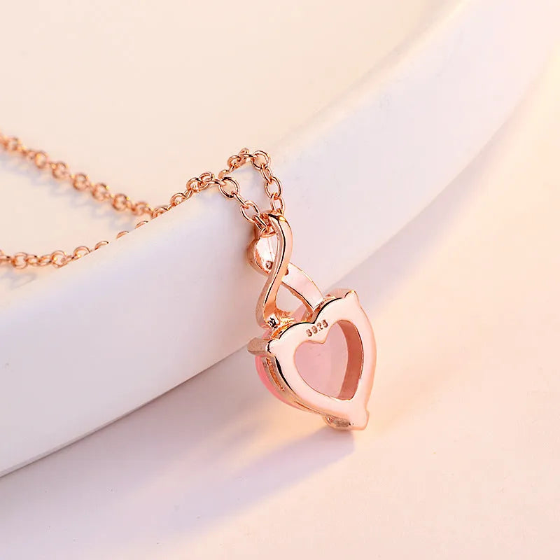 Women's rose gold heart pendant necklace with pink crystal on cross chain