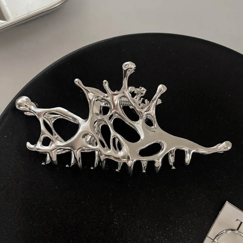 Assortment of silver metal hair claw barrettes with various designs including bows, pearls, and geometric shapes.