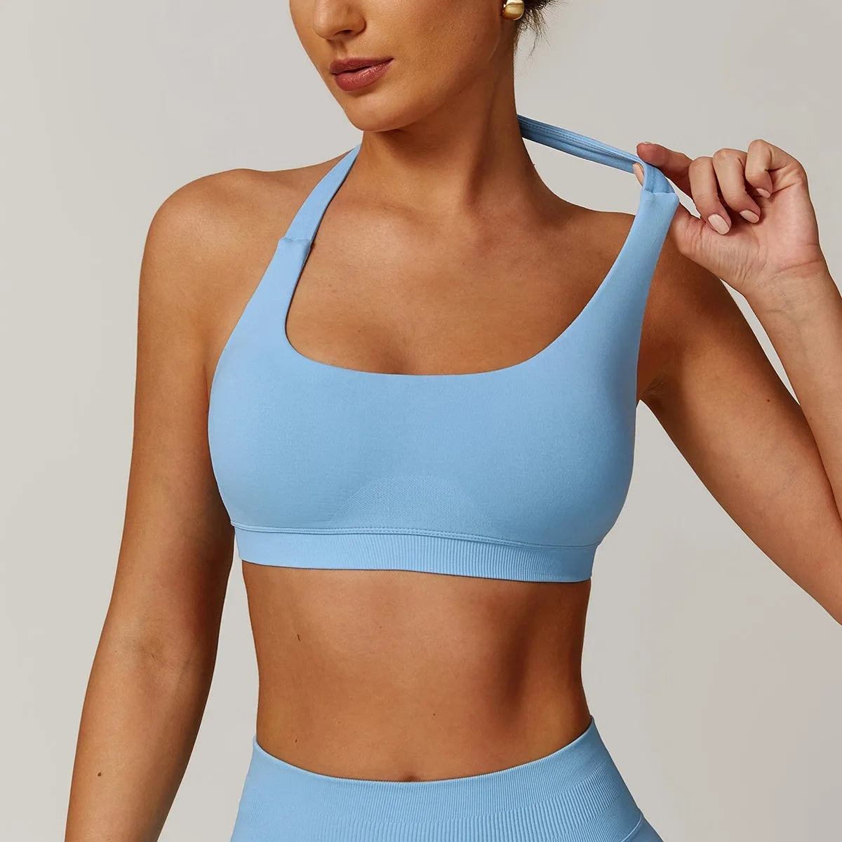 Women's black halter-neck yoga sports bra with removable padding on a mannequin.