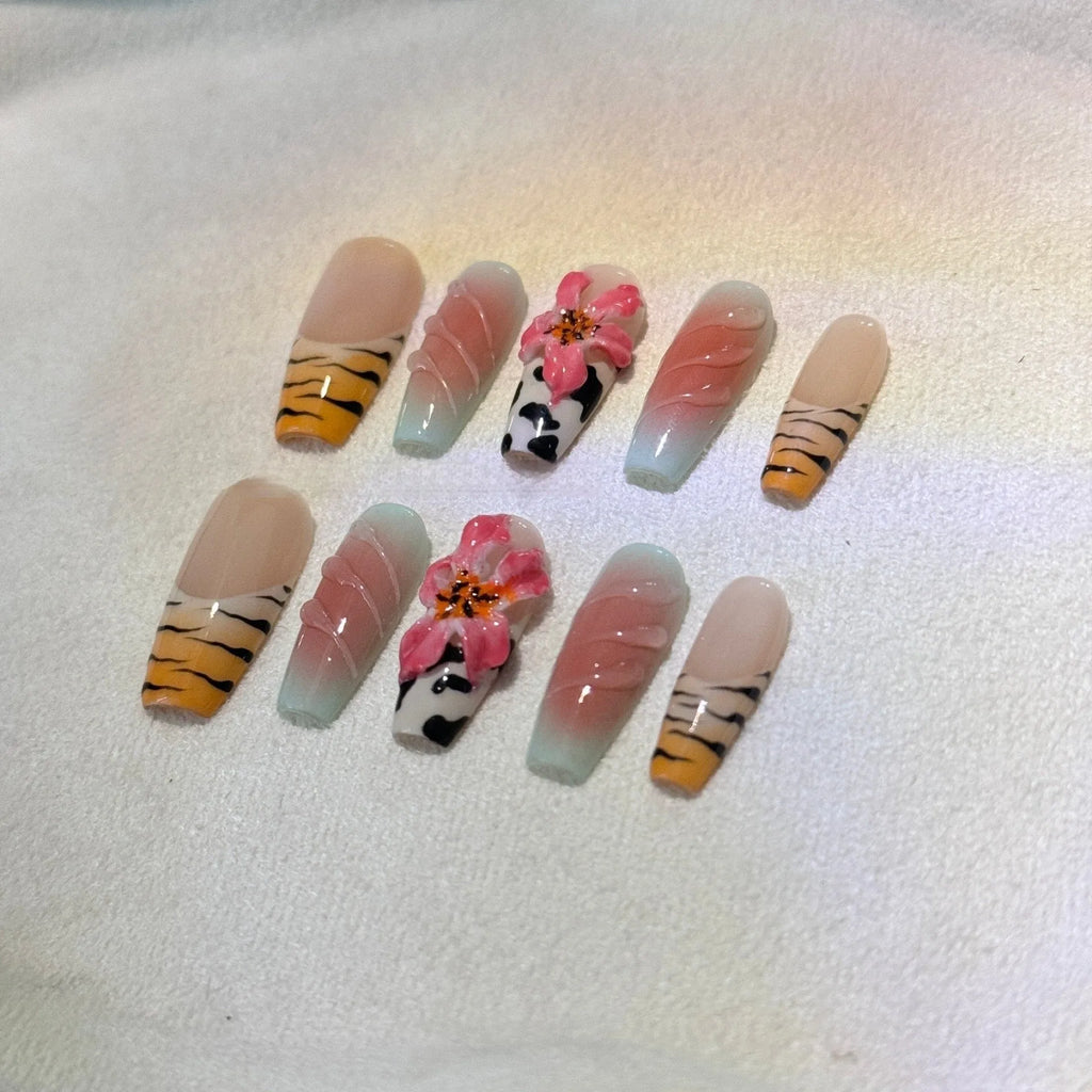 False nails with zebra pattern, carved lily design, and leopard print in long wear-resistant style.
