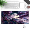 Large black gaming mouse pad with patterned design on a desk, showing keyboard and mouse placement.