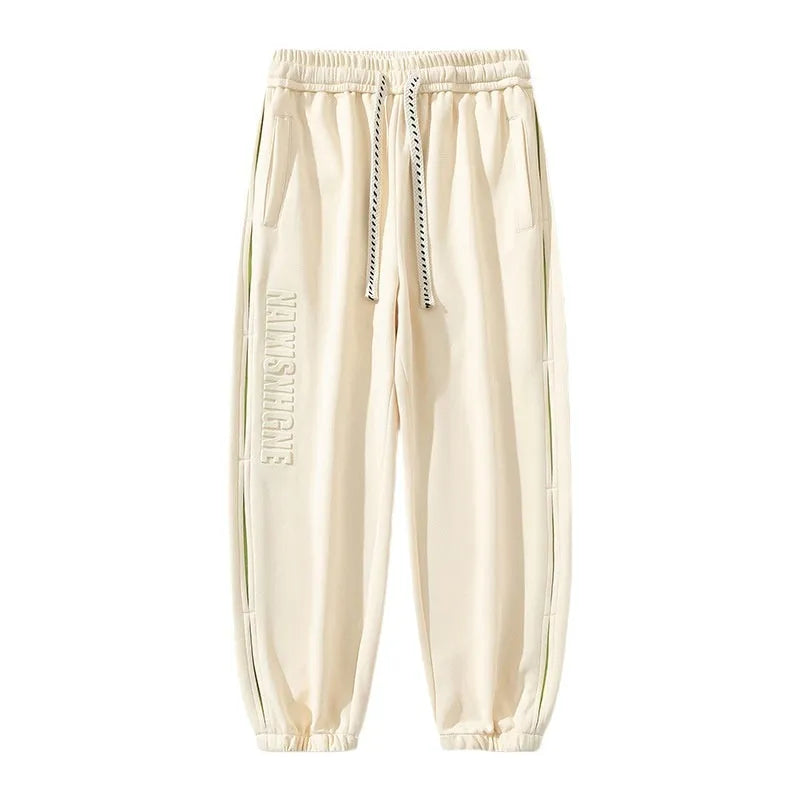 Men's loose grey green cotton trousers with ankle banding and stitching print detail on the leg.
