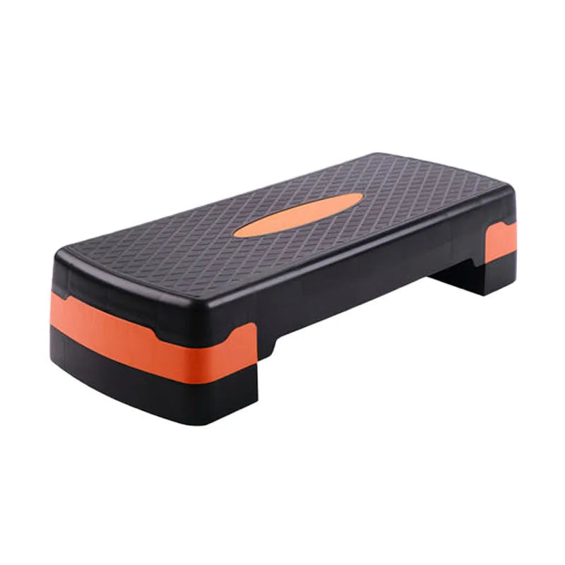 Grey, green, and orange fit step aerobics equipment on a plain background.