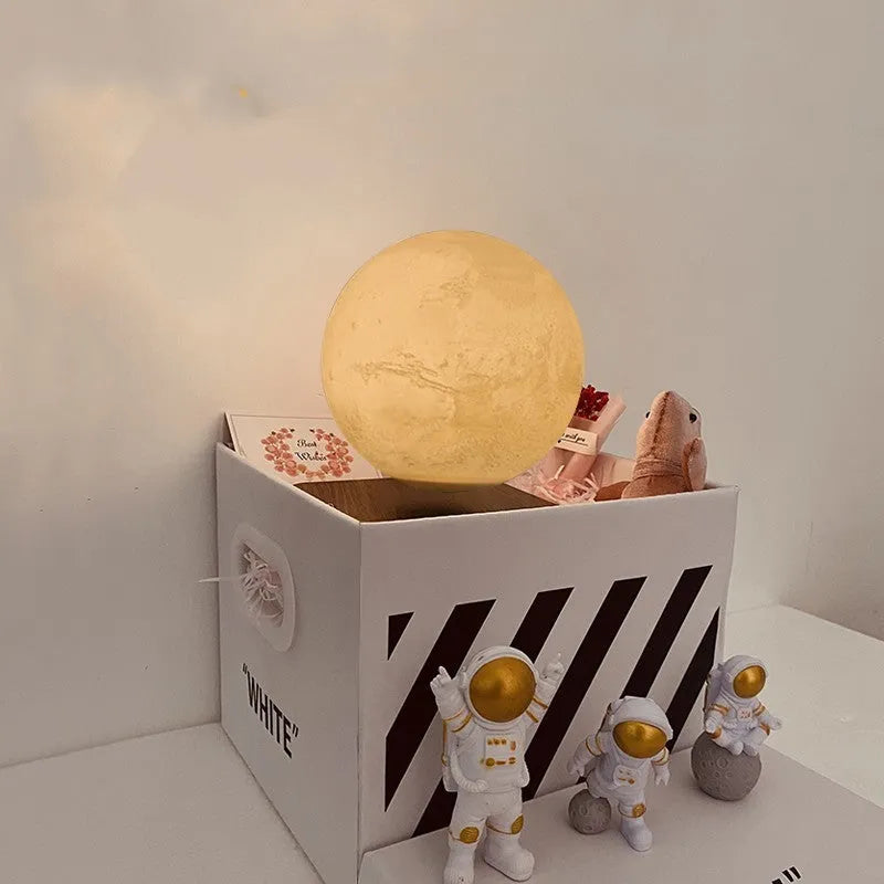 Maglev floating moon and earth night light with LED glow and small astronaut figurines on a table.