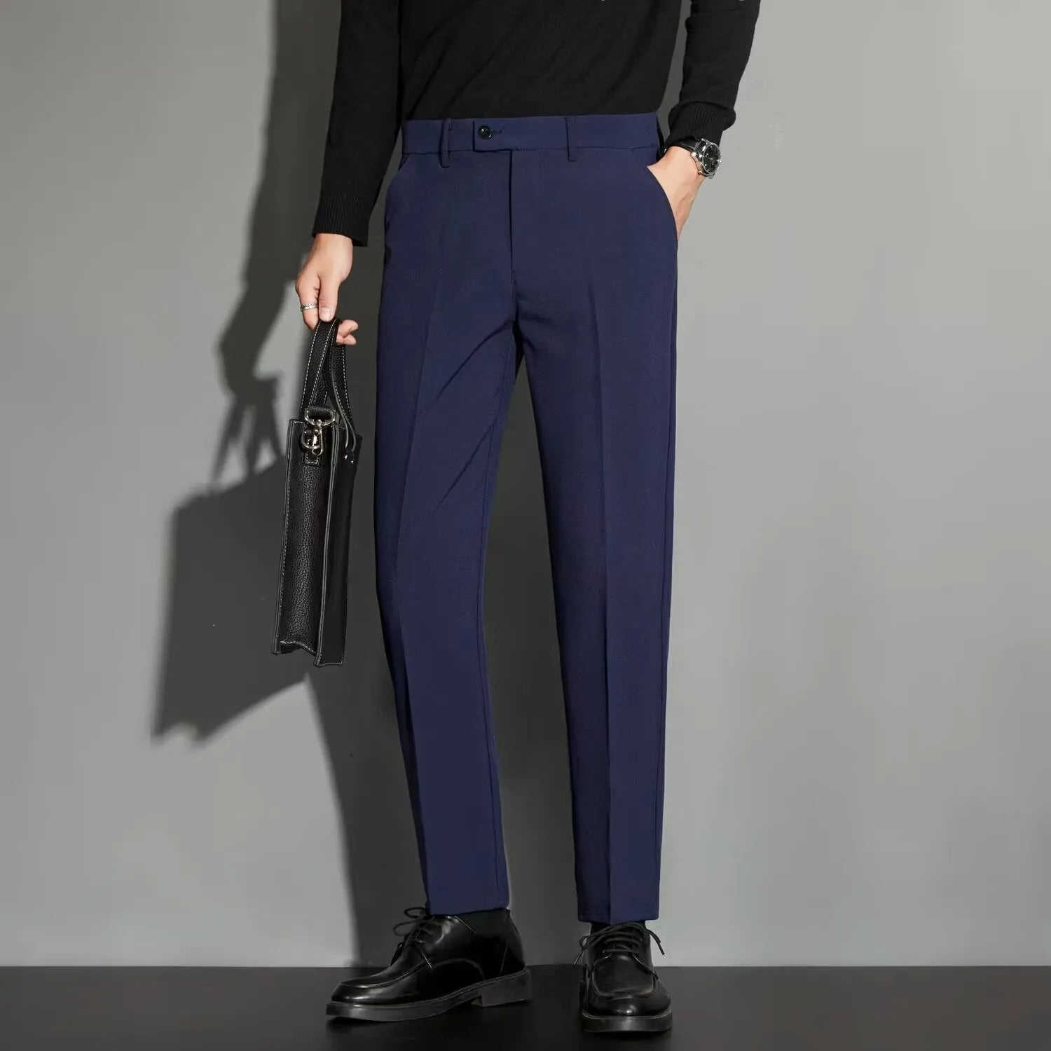 Man wearing straight-leg suit trousers with an ankle-length draping effect in a light colour.