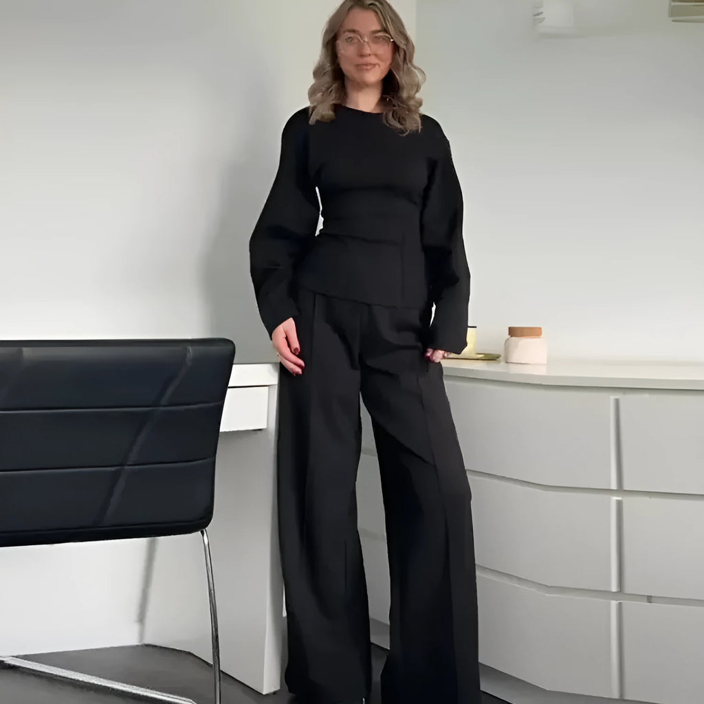 Women's black polar fleece long sleeve pleated top and wide leg trousers co-ord set on a hanger.