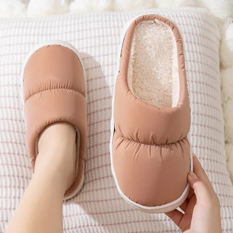 Blue down cotton indoor slippers with thick rubber sole and plush lining, shown on a wooden floor.