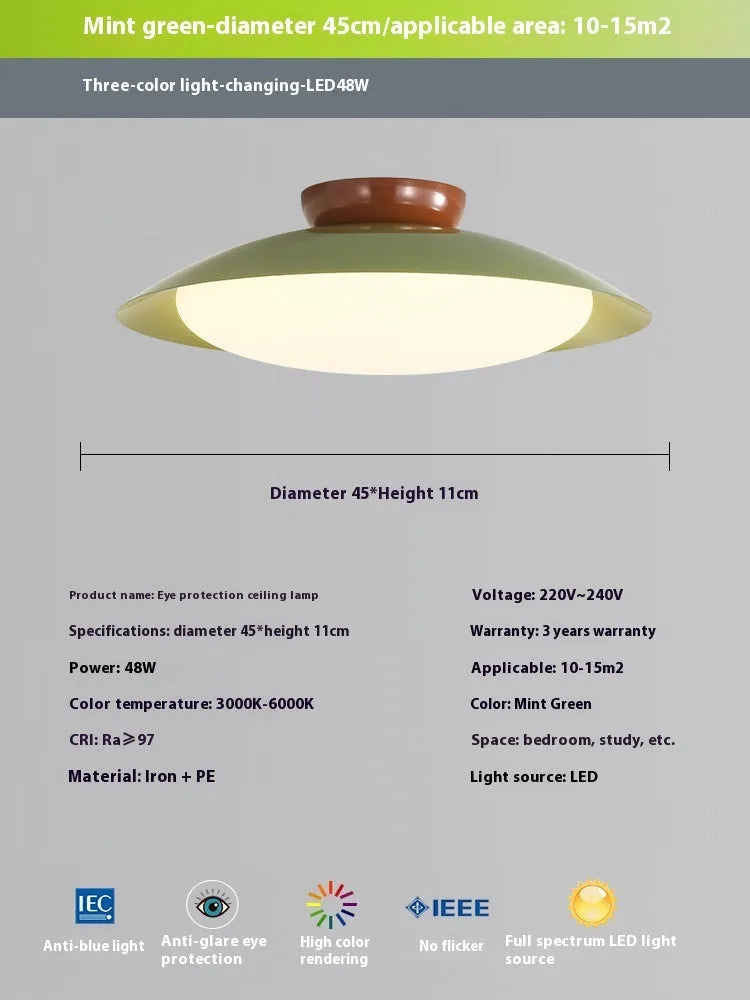 Modern minimalist flying saucer design ceiling lamp in cream yellow on a white ceiling.