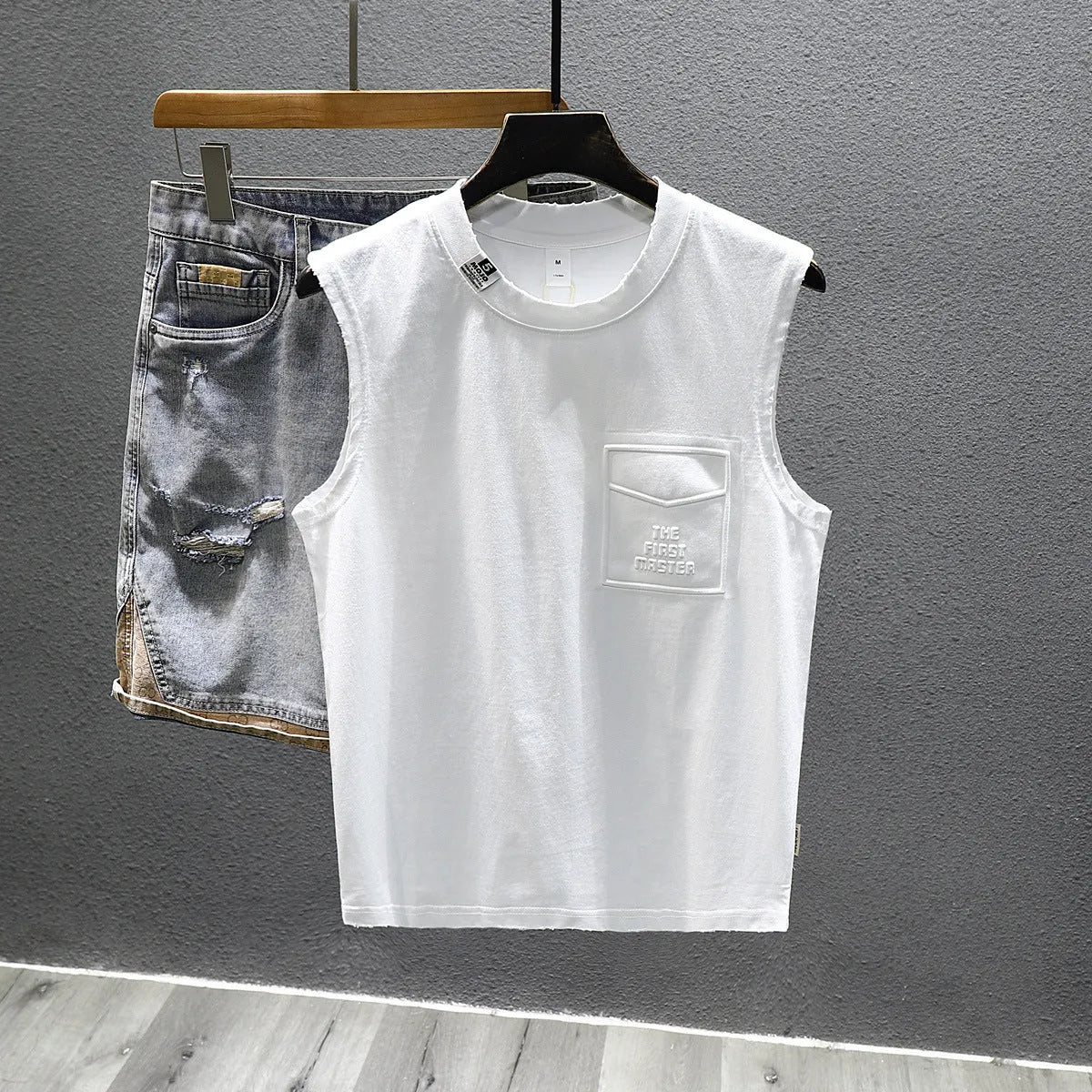 A black loose-fit cotton sleeveless t-shirt with a straight hem, laid flat.